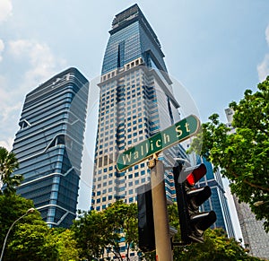 Wallich Street sign and traffic light red light over skycraper and summer blue sky