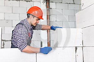Walling. bricklayer installing wall from autoclaved aerated concrete blocks
