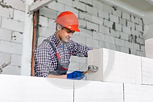 Walling. bricklayer installing wall from autoclaved aerated concrete blocks