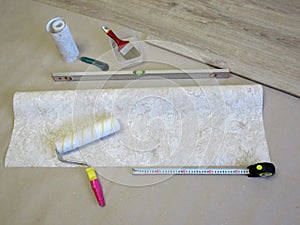 Wallpaper roller, tape measure and level