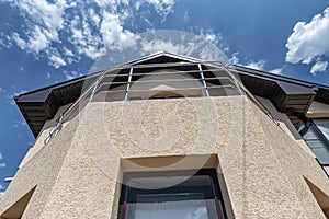 The walls of the cottage whose facade is plastered with decorative plaster