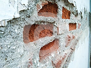 walls that have been damaged and visible red bricks