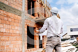walls, infrastructure on construction site. construction engineer reading plans, working on building construction site.