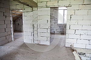 Walls from lightweight aggregate concrete block with empty doorframes, unfinished interior, house under construction photo
