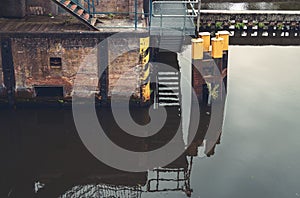 Walls of a lockage are reflected in the calm water