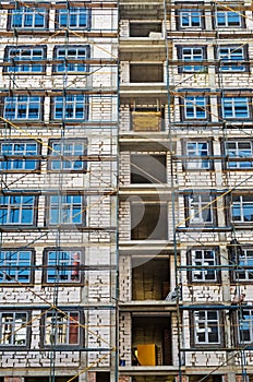 Walls of multi-storey building under construction in scaffolding