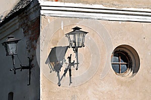 Walls of an old house with a round window and a lanterns in the