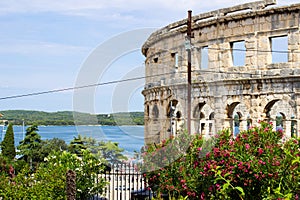 Walls of the Pula Arena, the only remaining Roman amphitheatre entirely preserved, in Pula, Croatia, with the sea at the