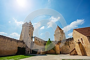 Walls and towers of Blandy-les-Tours castle over blue sky