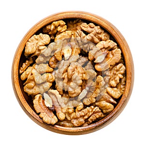 Walnut kernel halves, shelled and dried seeds, in a wooden bowl