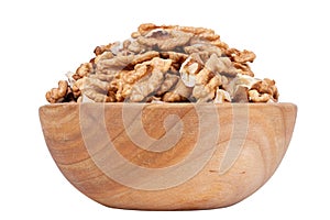 Walnut kernel halves, in wooden bowl isolated on white background. Shelled, dried seeds of the common walnut tree Juglans regia,