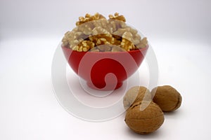 Walnut Kernels In Red Bowl Other Names: Juglans Regia, Persian Walnut, English Walnut, Circassian Walnut. Isolated Image On A