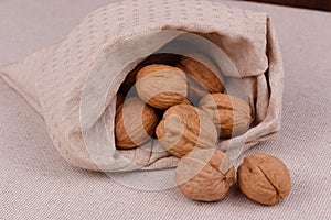Walnuts in a bag on a fabric background
