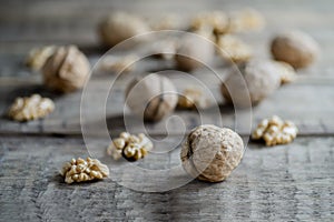 Walnut kernels and whole walnuts on rustic wooden table