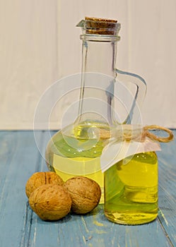 walnut oil in glass bottle on blue wooden background