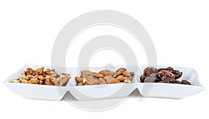 Walnuts almonds and dates in a white dish