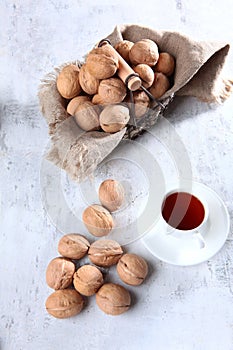 Walnuts in the basket. A cup of tea is next to it on the table. A natural, healthy product.