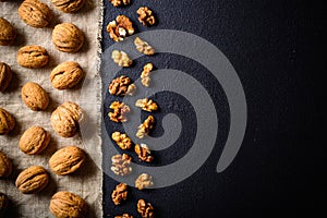 Walnuts on a black slate. Whole and peeled nuts. Walnuts spread out evenly.