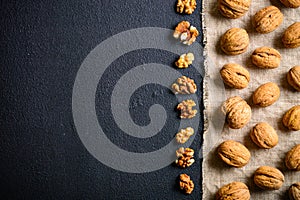 Walnuts on a black slate. Whole and peeled nuts. Walnuts spread out evenly.