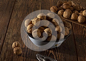 Walnuts in a blue plate on a wooden table