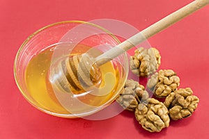 Walnuts and bowl of honey on a table