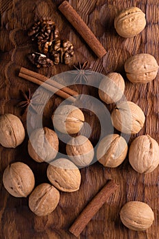 Walnuts, cinnamon and anise on wooden cutting board. Nuts and spices on the table. Food composition.