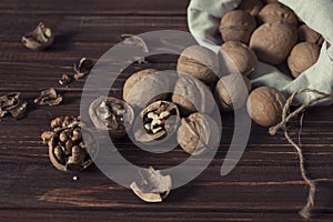 Walnuts in a cotton bag on an old wooden table still life