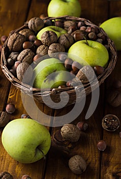 Walnuts with green apples mixed with a wicker basket