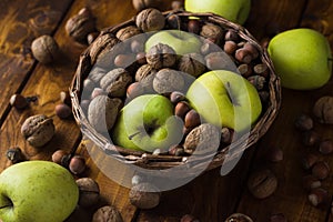 Walnuts with green apples mixed with a wicker basket