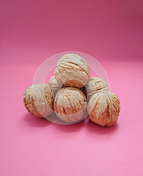 Walnuts Juglans regia on pink background close up