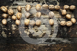 Walnuts, laid out in the word nuts on wooden rustic background, top view