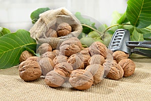 Walnuts with leaf and nutcracker on sackcloth