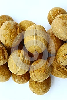 Walnuts lie in a pile on a white background