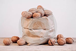 Walnuts in a paper bag on a old rustic table. Walnuts in a paper bag. Copy, empty space for text