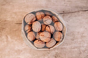 Walnuts in a paper bag on a old rustic table. Walnuts in a paper bag. Top view. Copy, empty space for text