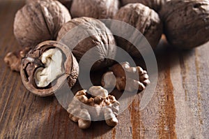 Walnuts peeled and inshell. Brown wooden background. Healthy nutrition, health care, diet. Healthy, fresh and nutritious food