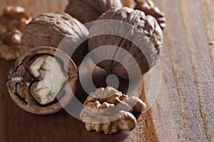 Walnuts peeled and inshell. Brown wooden background. Healthy nutrition, health care, diet. Healthy, fresh and nutritious food.