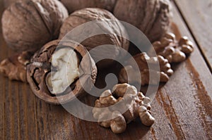Walnuts peeled and inshell. Brown wooden background. Healthy nutrition, health care, diet. Healthy, fresh and nutritious food.