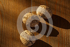 Walnuts on a rustic old wooden table. Three walnuts on a wooden table. Side view.