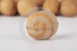 Walnuts on a white background, one nut in the foreground