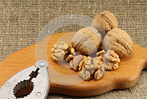 Walnuts on a wooden board (cutting board) with a nutcracker