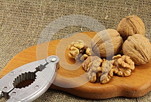 Walnuts on a wooden board (cutting board) with a nutcracker