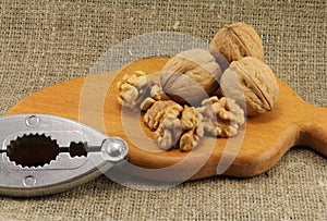 Walnuts on a wooden board (cutting board) with a nutcracker