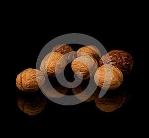 Walnuts with yellow autumn leaves isolated on black background