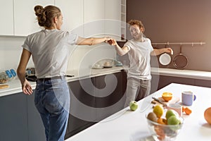 Waltzing in a new home young couple dancing celebrating their new purchase of buying their own house. Happy new family