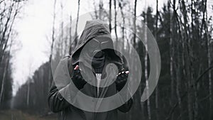 Wanderer man in gas mask standing on railway in forest after nuclear disaster