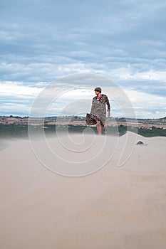 Wanderer walking in the desert. Young man standing in white sand dunes