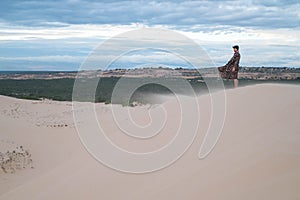 Wanderer walking in the desert. Young man standing in white sand dunes.