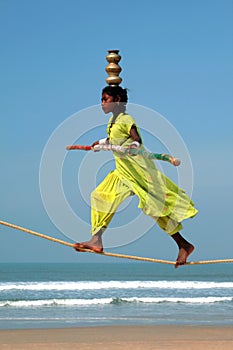 Wandering indian tightrope walker playing on the beach of Goa