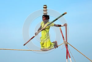 Wandering indian tightrope walker playing on the beach of Goa